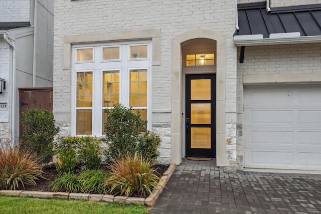 entrance to property with metal roof, brick siding, and a standing seam roof