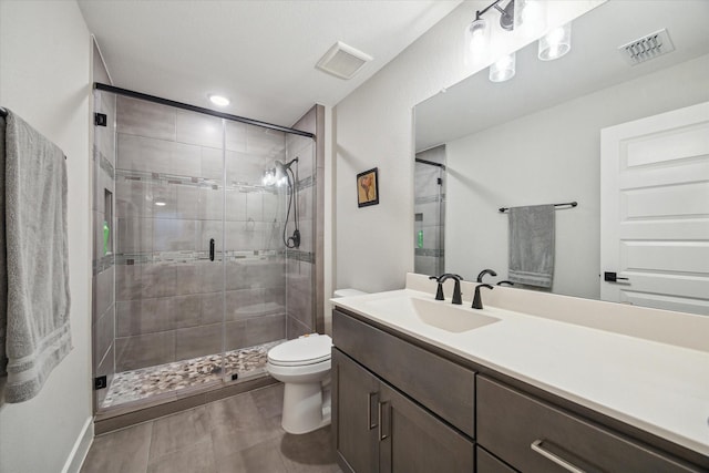 bathroom featuring vanity, toilet, and a shower with door