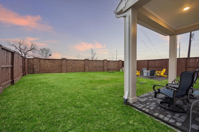 yard at dusk with a patio area and an outdoor fire pit