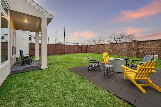 yard at dusk with a patio area and an outdoor fire pit