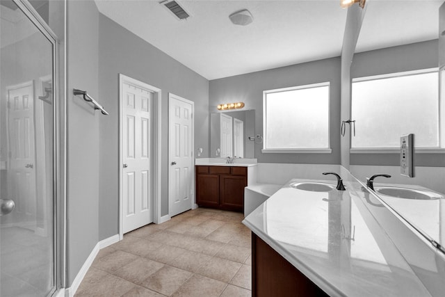 bathroom featuring vanity, tile patterned floors, and a shower with shower door