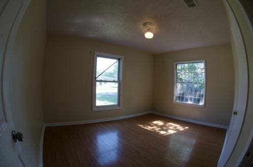 unfurnished room with dark hardwood / wood-style flooring