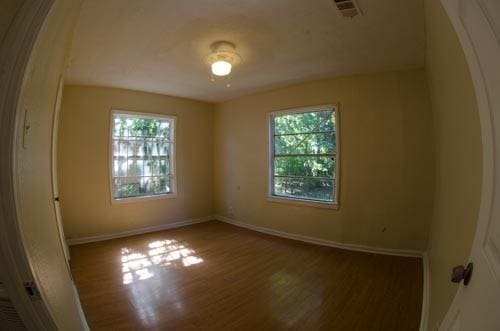 empty room featuring plenty of natural light and hardwood / wood-style floors