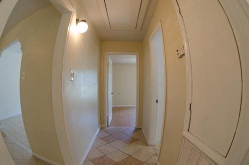 hall with light tile patterned floors