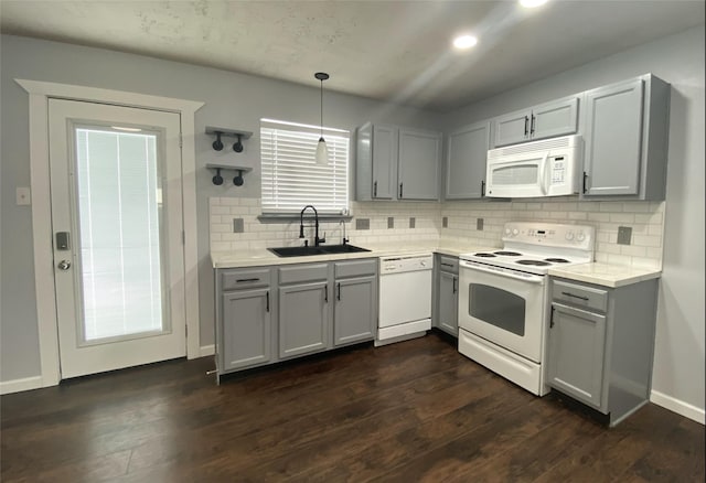 kitchen with gray cabinets, sink, white appliances, and decorative light fixtures