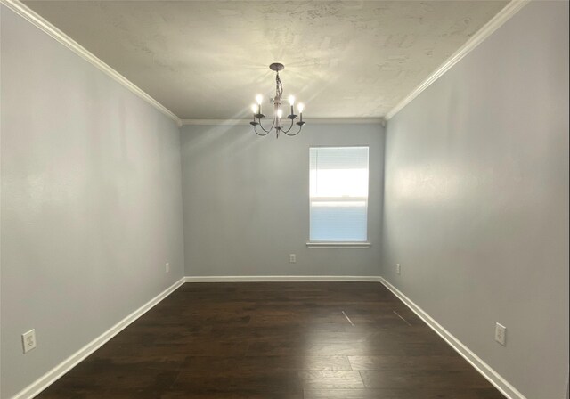 spare room featuring ornamental molding, dark hardwood / wood-style floors, and a chandelier