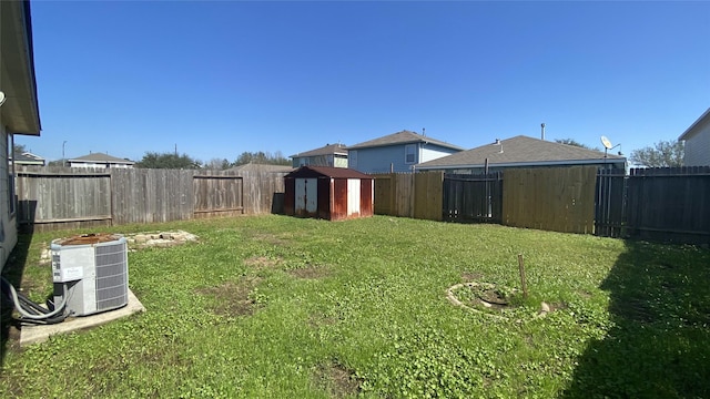 view of yard featuring a storage unit and central air condition unit