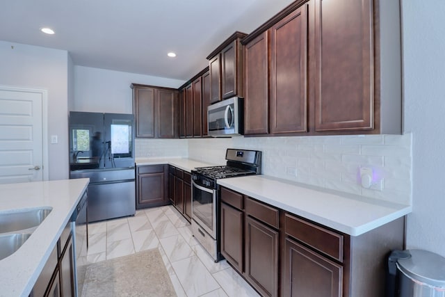 15158 N Heron Heights Way, Magnolia, TX 77354 - kitchen featuring backsplash, stainless steel appliances, dark brown cabinets, and light countertops
