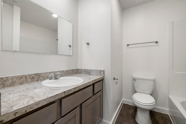 bathroom featuring wood-type flooring, toilet, and vanity