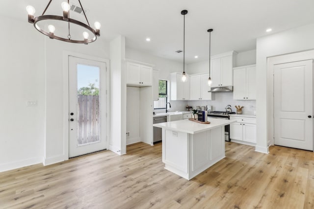 kitchen with a kitchen island, pendant lighting, white cabinetry, sink, and stainless steel appliances