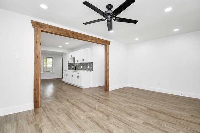 unfurnished living room featuring light wood-type flooring, baseboards, and recessed lighting