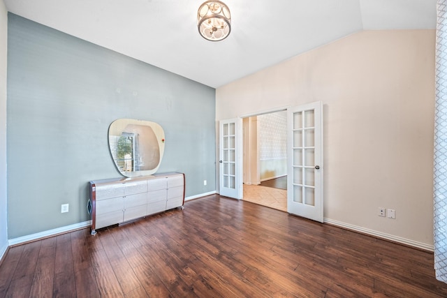 interior space featuring baseboards, vaulted ceiling, dark wood-type flooring, and french doors