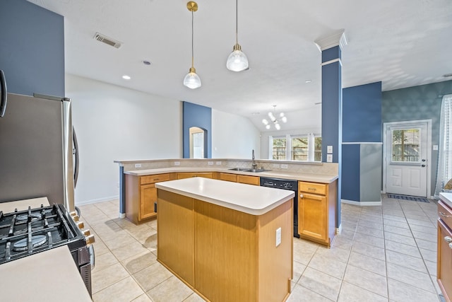 kitchen with a center island, stainless steel appliances, light countertops, visible vents, and a sink