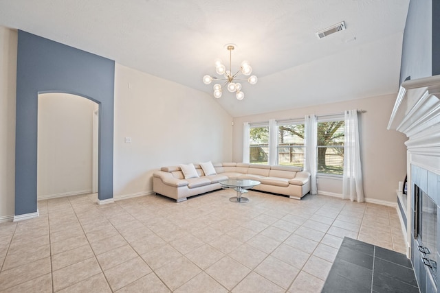 living room with arched walkways, light tile patterned floors, a tile fireplace, visible vents, and vaulted ceiling