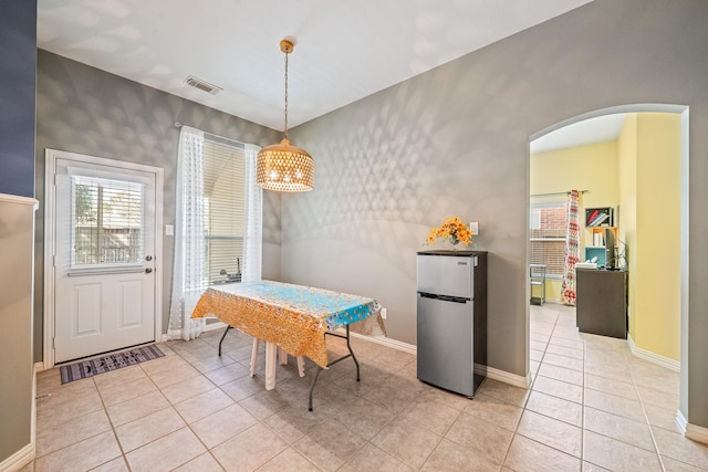 dining area with arched walkways, a healthy amount of sunlight, and baseboards