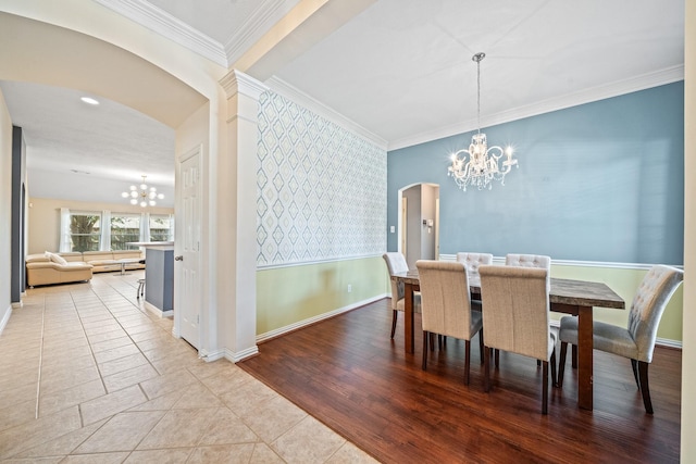 dining space featuring arched walkways, ornamental molding, baseboards, and an inviting chandelier