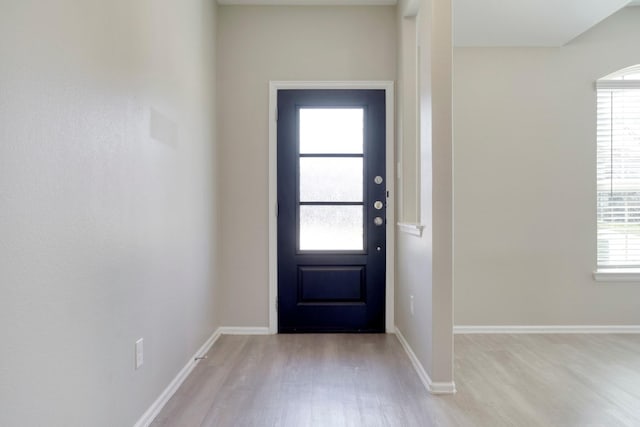 foyer entrance featuring light wood-type flooring and baseboards