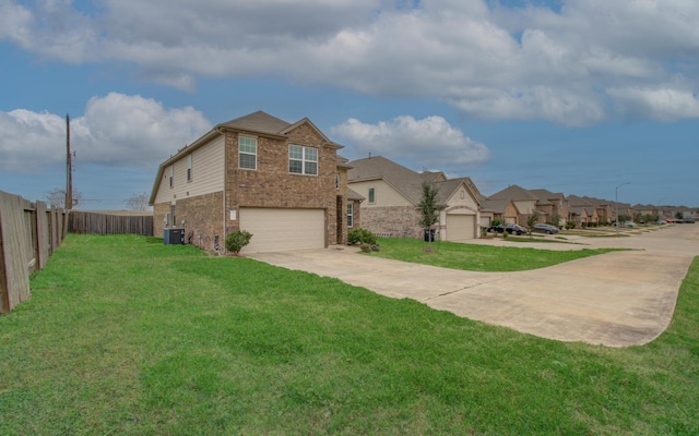 view of front of house featuring a garage, cooling unit, and a front yard