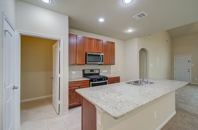 kitchen featuring sink, backsplash, an island with sink, and appliances with stainless steel finishes