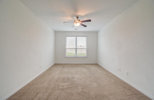 spare room with ceiling fan and light carpet