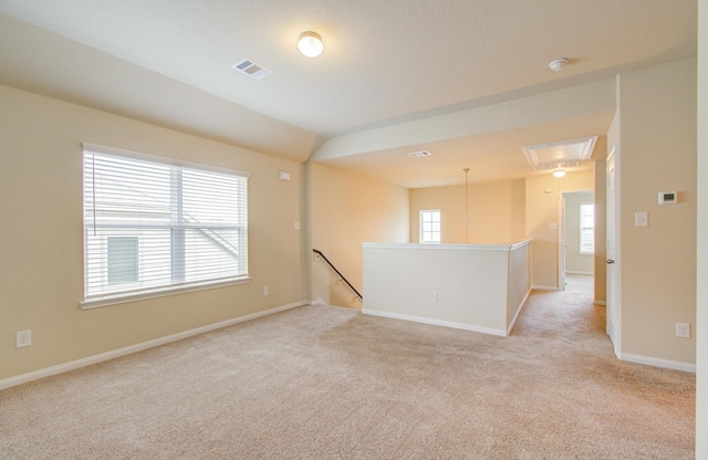 spare room with lofted ceiling and light carpet