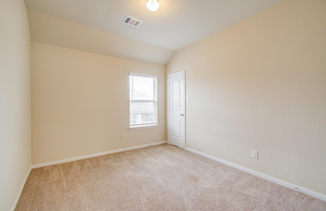 unfurnished room featuring lofted ceiling and light carpet