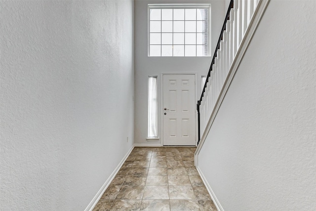 tiled entrance foyer with a towering ceiling