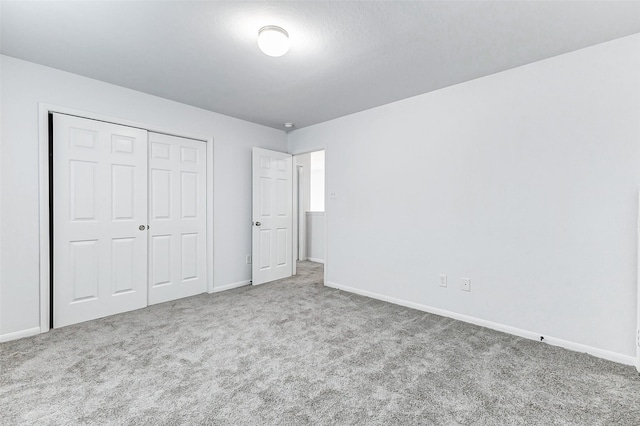 unfurnished bedroom featuring light carpet and a closet