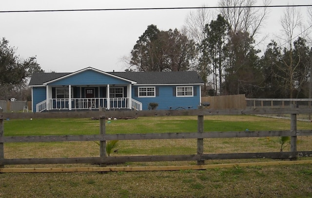 ranch-style home featuring covered porch and a front lawn