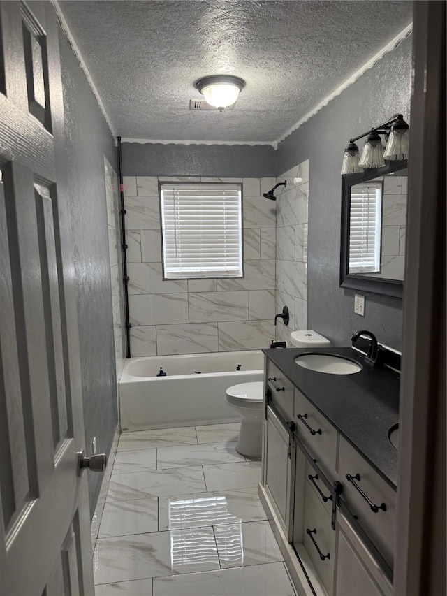 full bathroom with a textured ceiling, toilet, vanity, and tiled shower / bath combo