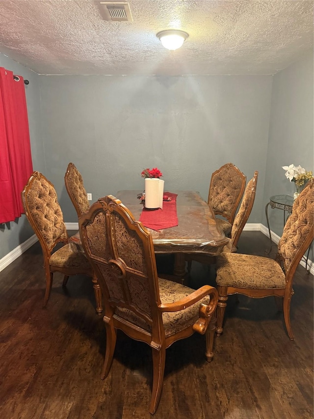 dining room with a textured ceiling and wood-type flooring