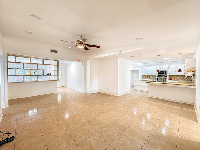 unfurnished living room featuring light tile patterned flooring and ceiling fan