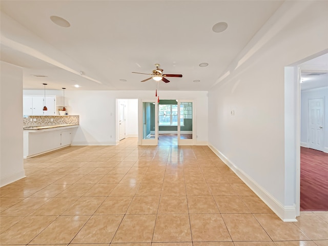 unfurnished living room featuring light tile patterned floors and ceiling fan