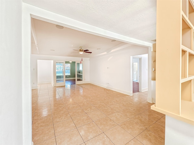 tiled spare room with ceiling fan and a textured ceiling