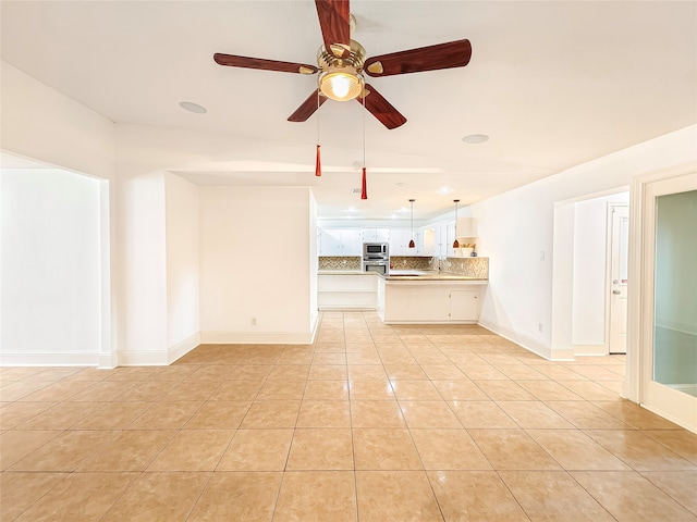 unfurnished living room featuring sink, light tile patterned floors, and ceiling fan