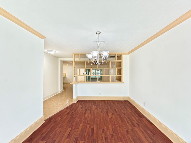 interior space with wood-type flooring, ornamental molding, and a chandelier