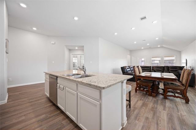 kitchen with a center island with sink, visible vents, dishwasher, wood finished floors, and a sink