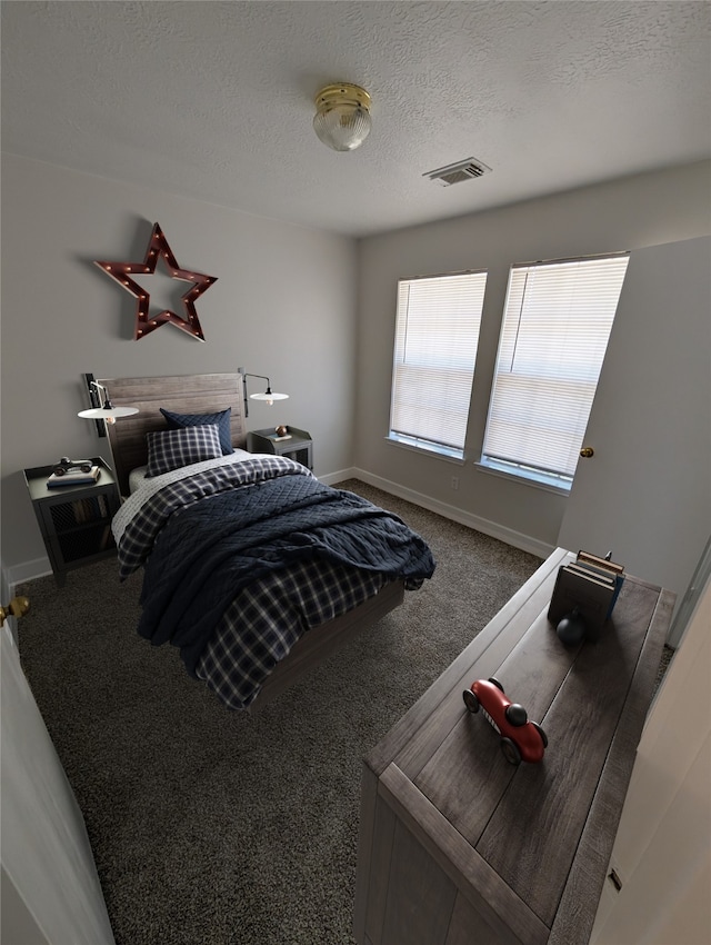 carpeted bedroom with visible vents, baseboards, and a textured ceiling