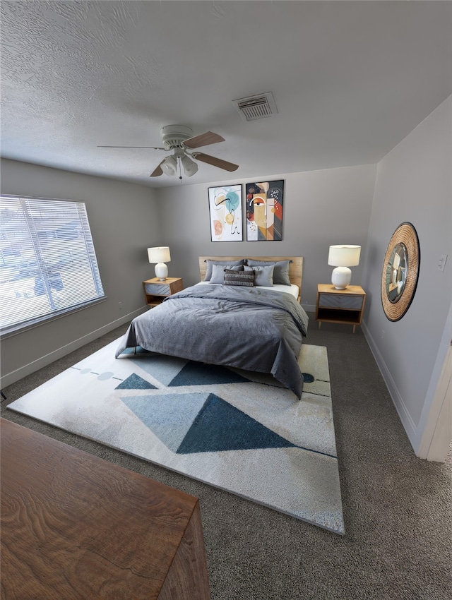 carpeted bedroom with visible vents, baseboards, a textured ceiling, and a ceiling fan