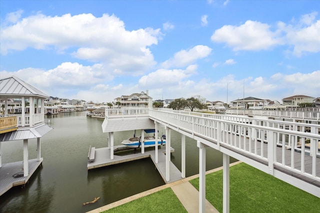 dock area with a water view, boat lift, and a residential view