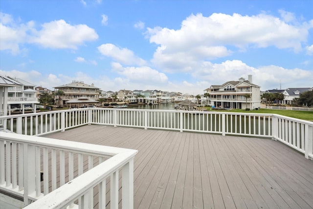 wooden terrace with a residential view and a water view