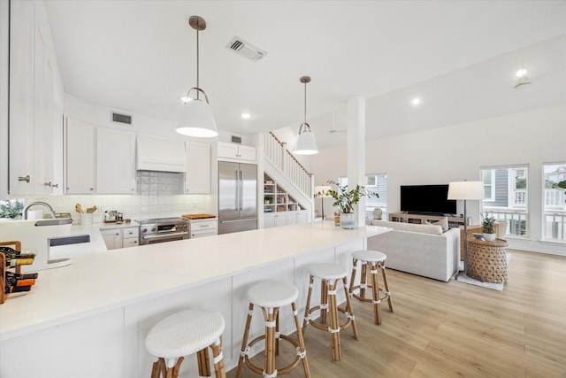 kitchen featuring a healthy amount of sunlight, tasteful backsplash, visible vents, and premium appliances