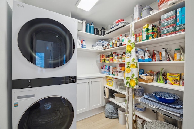 washroom with stacked washer / dryer and light wood finished floors