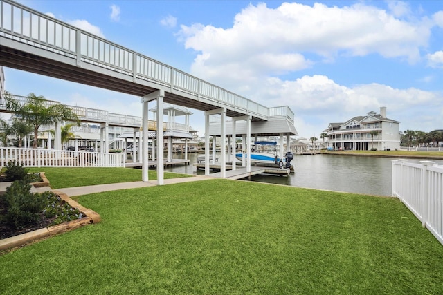 dock area with boat lift, a yard, a water view, and fence