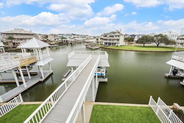 view of dock with a residential view and a water view