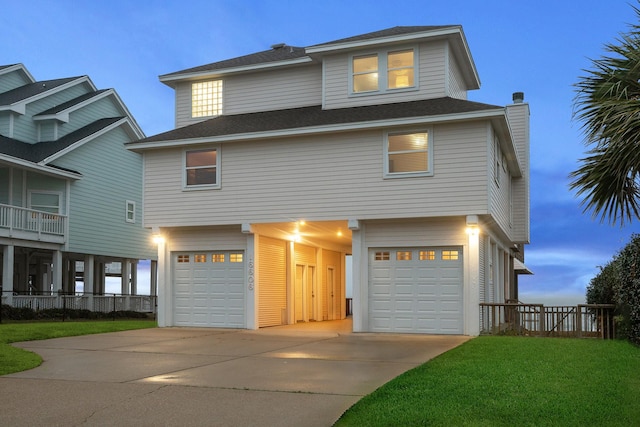 raised beach house with driveway, roof with shingles, an attached garage, and a front yard