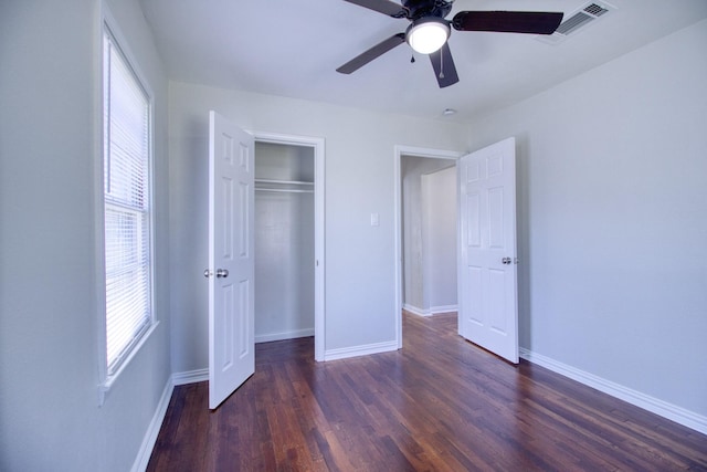 unfurnished bedroom featuring ceiling fan, dark hardwood / wood-style floors, and a closet