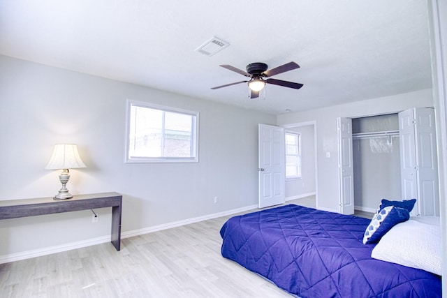 bedroom with light wood-type flooring, a closet, and ceiling fan