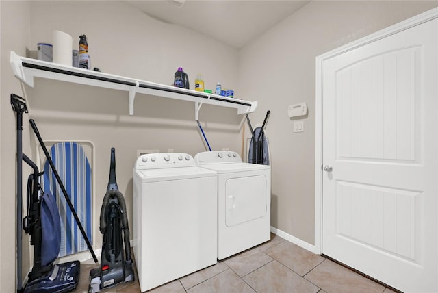 clothes washing area with light tile patterned flooring and separate washer and dryer