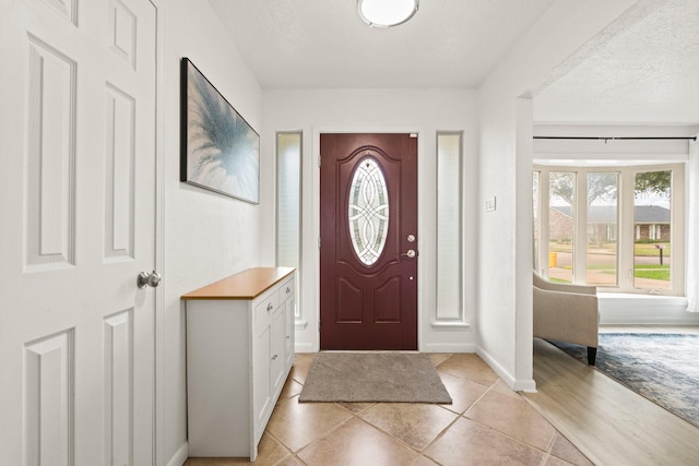 tiled entrance foyer with a textured ceiling